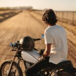 Man sitting on his vintage bike in countryside